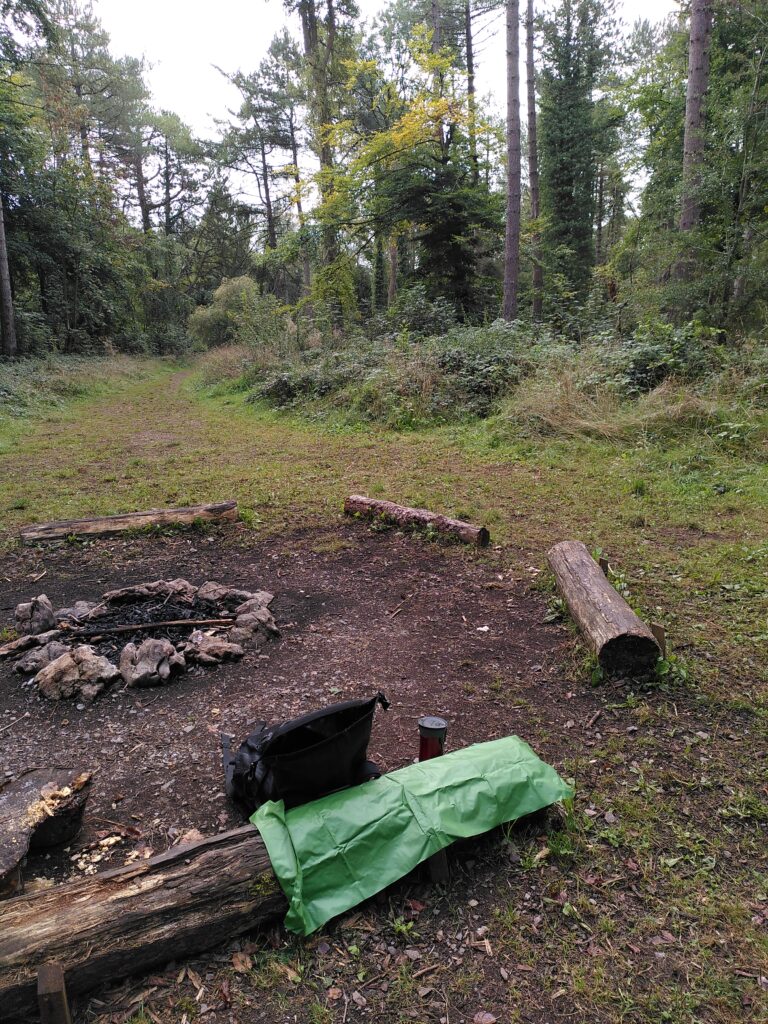 A rucksack, rug and thermos of tea in a clearing in the woods